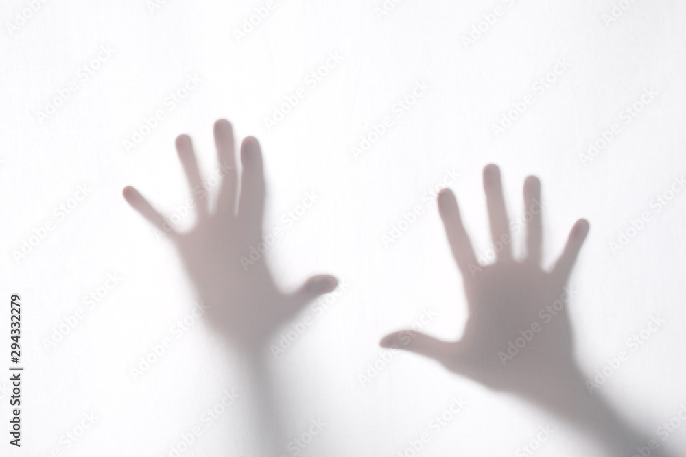 shadow or silhouette of two man's hands touching a white fabric from behind  in transparncy with copy space for your text