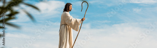 Canvas Print panoramic shot of man holding wooden cane in desert