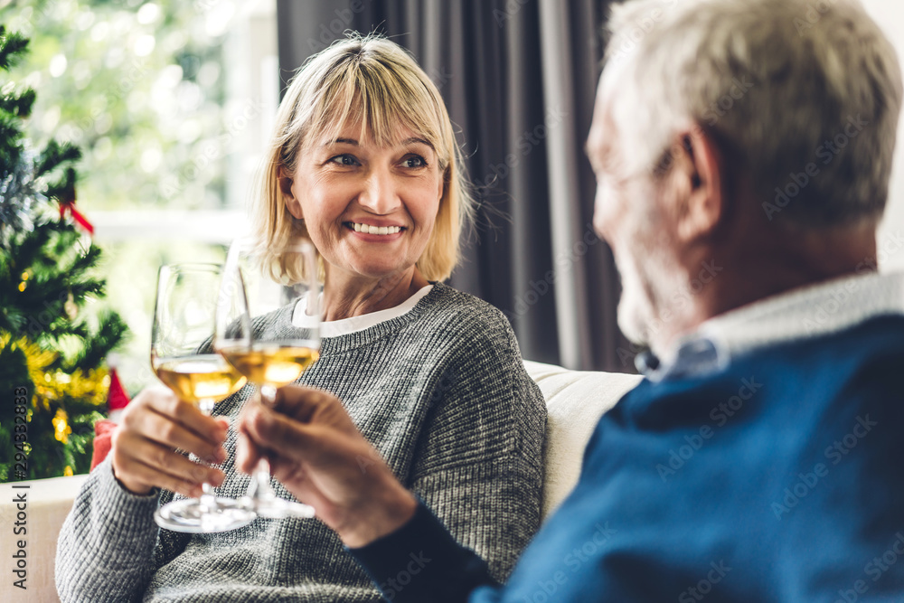 Senior couple relax talking and drinking wine glasses together on sofa in living room at home.Retirement couple concept Senior couple relax talking and drinking wine glasses together on sofa in living room at home.Retirement couple concept