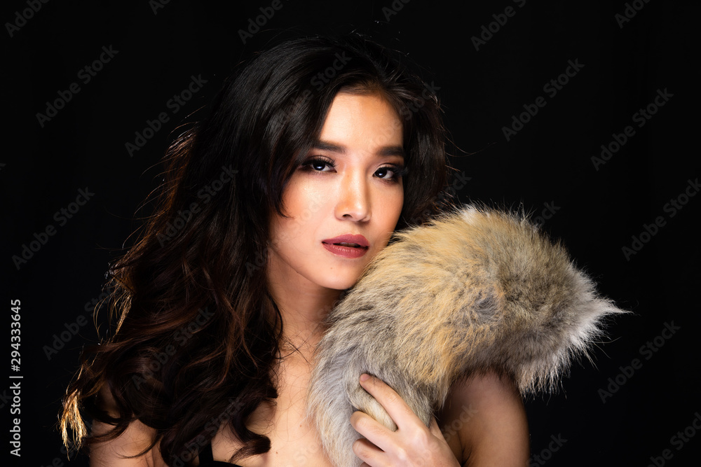 Sensual Look of Fashion Model High Make Up curl style hair Red Lips, Woman wear Fur and look at camera in beauty shot, studio lighting dark fog smoke background backlit light