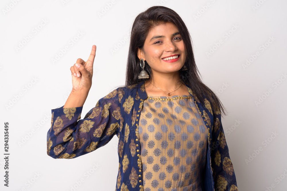 Happy young Persian woman pointing up in traditional clothing Happy young Persian woman pointing up in traditional clothing