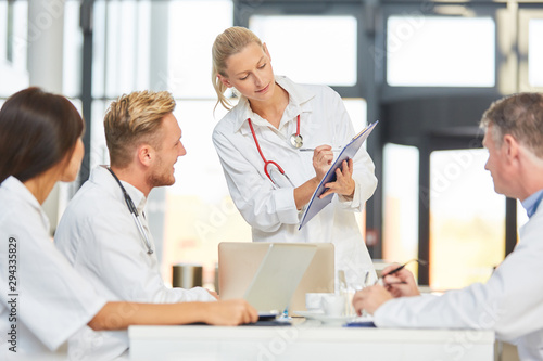 Female doctor giving a presentation in meeting with clipboard