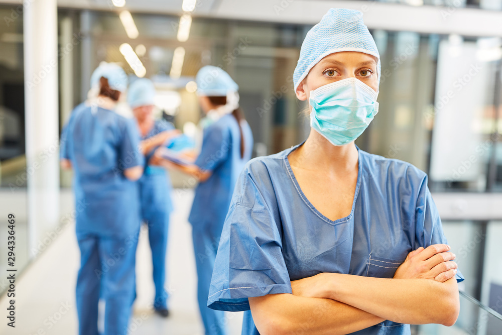 Obraz premium Woman as a surgeon in front of doctors team in clinic