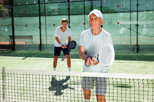 mature man and young man playing padel court © caftor
