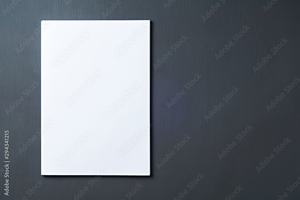 Single heap of blank white paper sheets lies on dark concrete table on workplace of secretary, director, boss or other worker of company. Space for text. Top view