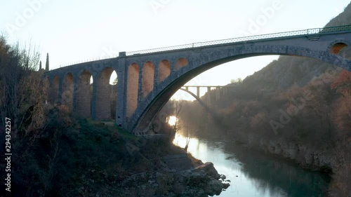 Aerial - Large arched stone bridge side view in sunset, Solkan Slovenia photo