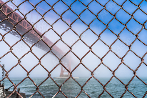 Dramatic Golden Gate Bridge through fence.