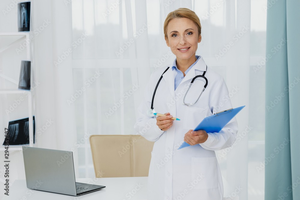 Doctor holding clipboard looking at camera Doctor holding clipboard looking at camera