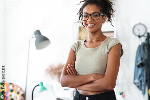 African woman in office looking camera indoors.