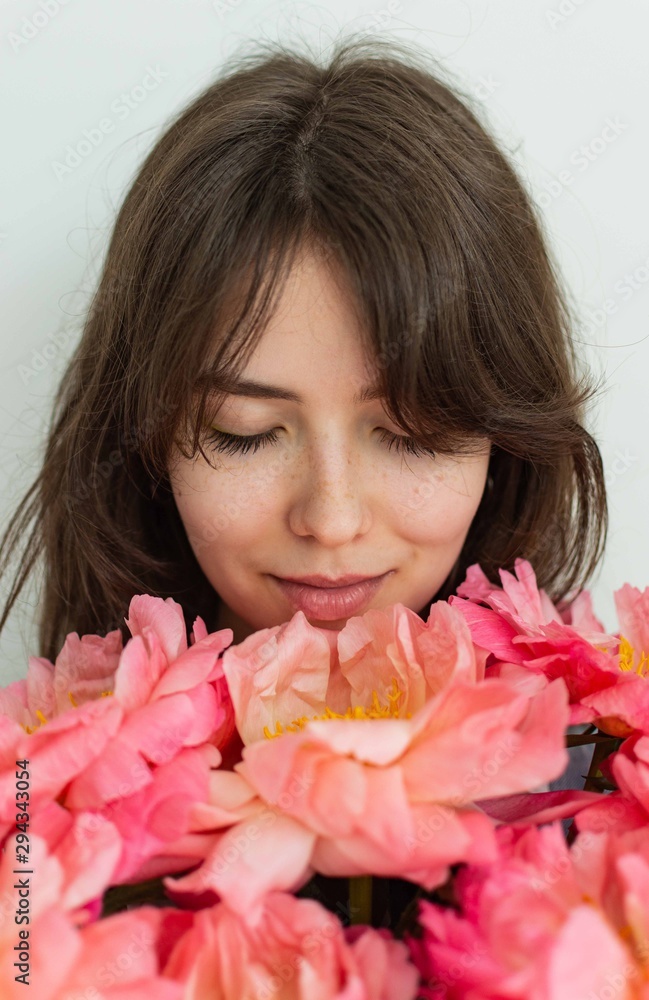 Beautiful happy girl smiling on her birthday, face of a girl close up with peonies, valentine\'s day Beautiful happy girl smiling on her birthday, face of a girl close up with peonies, valentine\'s day