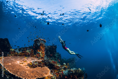 Fényképezés Free diver girl swimming underwater over wreck ship.