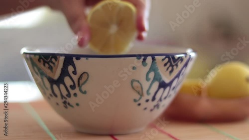 Woman squeezing lemon into soup