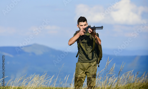 soldier in the field. polygon. muscular man hold weapon. purpose and success. army forces. sniper reach target mountain. military style. male in camouflage. man ready to fire. hunter hobby