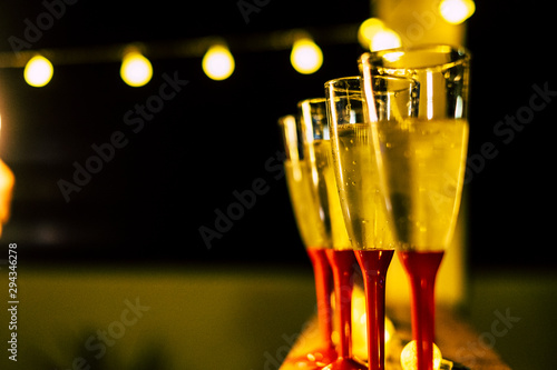 close up of four glasses with champagne the night of the new year ready to celebrate it - night and dark background photo