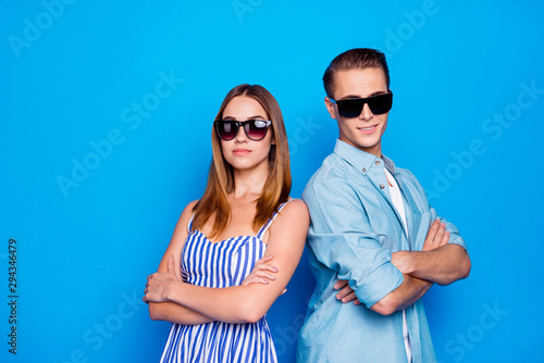 Portrait of his he her she two nice attractive confident content people partners wearing sun specs folded arms isolated on bright vivid shine vibrant blue color background