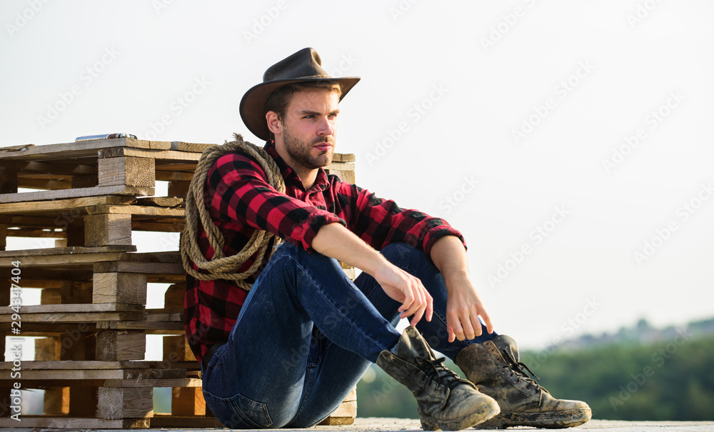 Fototapeta premium being a Texan. Vintage style man. Wild West retro cowboy. cowboy with lasso rope. Western. wild west rodeo. Thoughtful man in hat relax. western cowboy portrait. man checkered shirt on ranch