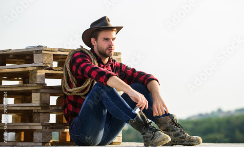 being a Texan. Vintage style man. Wild West retro cowboy. cowboy with lasso rope. Western. wild west rodeo. Thoughtful man in hat relax. western cowboy portrait. man checkered shirt on ranch photo