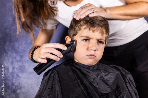 Little boy getting a haircut with a cutting machine