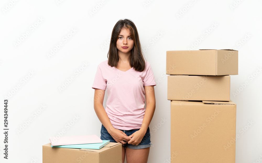 Young girl moving in new home among boxes sad Young girl moving in new home among boxes sad