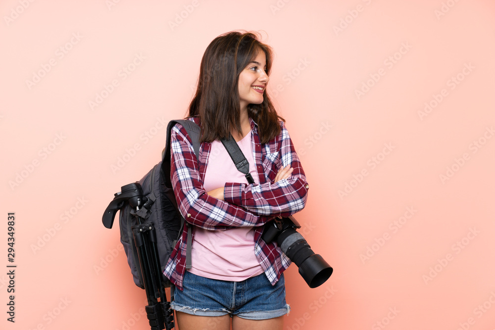 Young photographer girl over isolated pink background looking to the side Young photographer girl over isolated pink background looking to the side