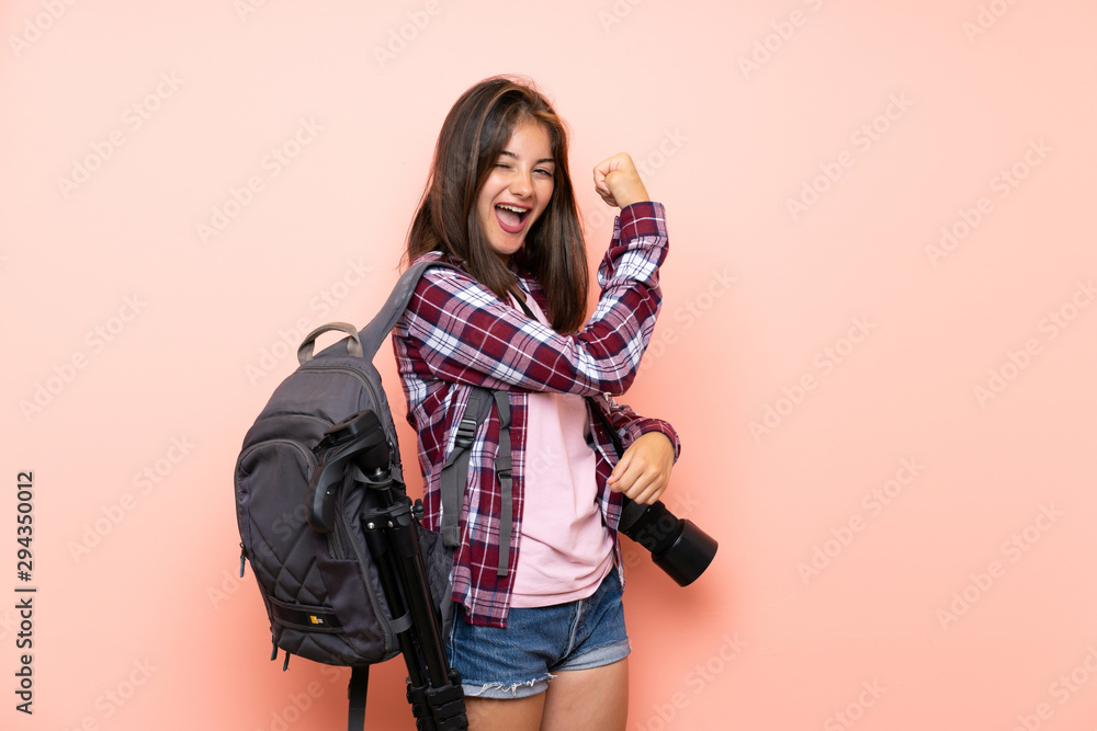 Young photographer girl over isolated pink background making strong gesture Young photographer girl over isolated pink background making strong gesture