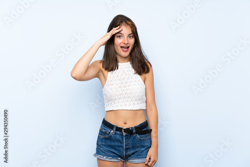 Young woman over isolated blue background has just realized something and has intending the solution