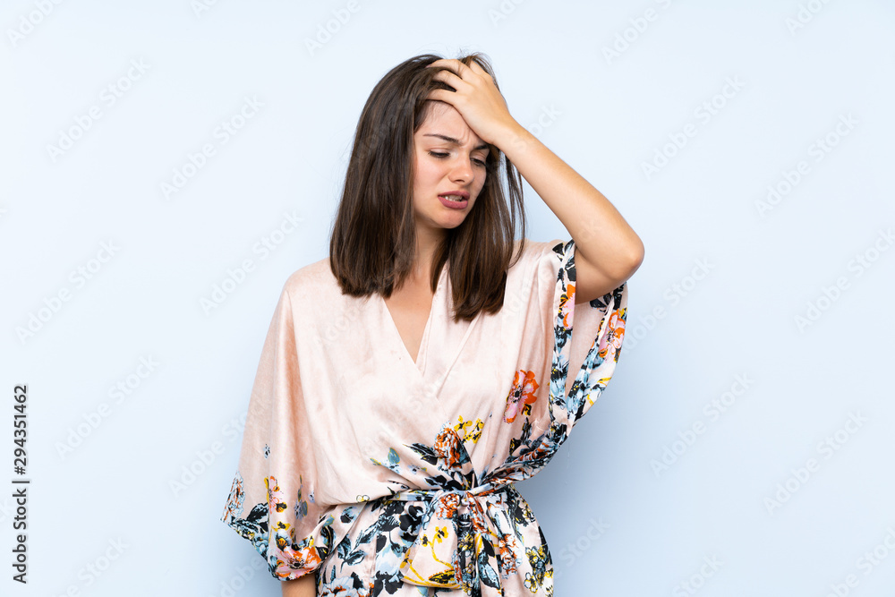 Caucasian girl with kimono over isolated blue background having doubts with confuse face expression Caucasian girl with kimono over isolated blue background having doubts with confuse face expression