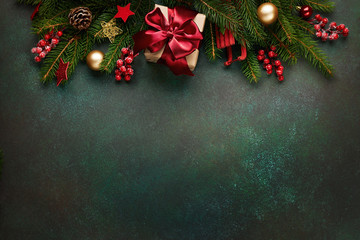 Xmas presents with decoration and fir branches on green background.