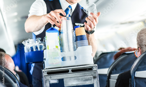 The steward serving glass of water for passengers on board.