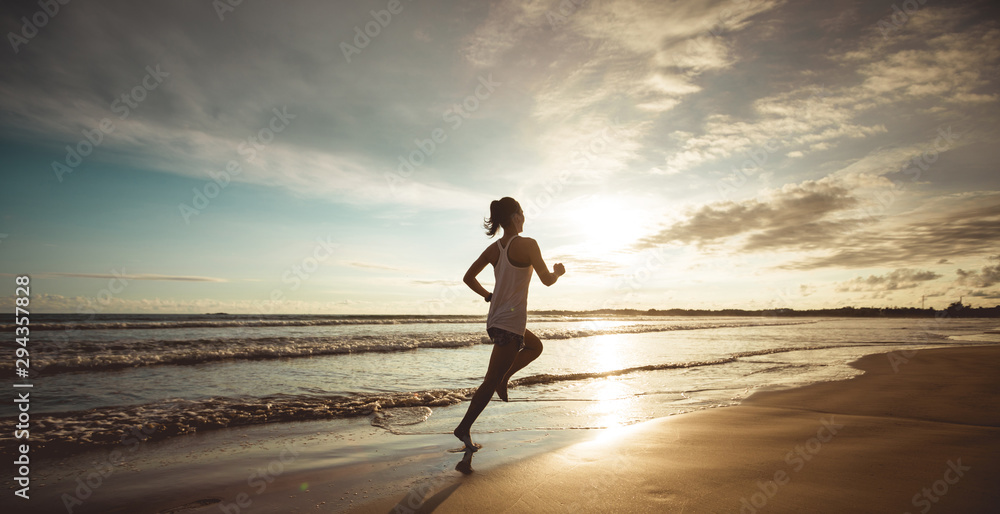 Fitness woman runner running on sunset beach - obrazy, fototapety, plakaty 