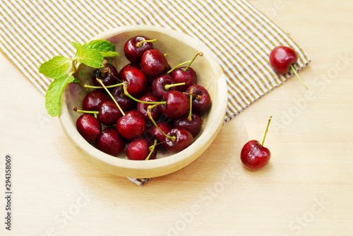 Red  cherry  on wooden bowl , fresh  fruit image for background  orwallpaper.
