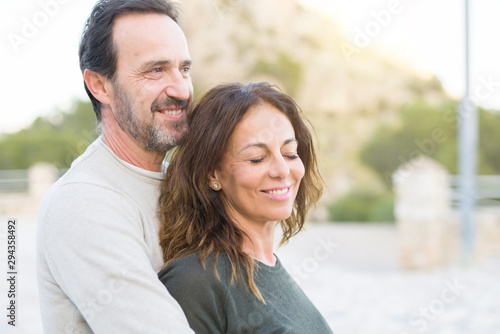 Romantic couple smiling, cuddling and hugging on a sunny day