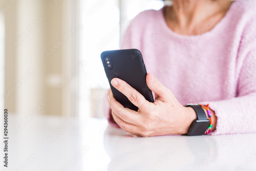 Close up of senior woman using smartphone over white table Close up of senior woman using smartphone over white table