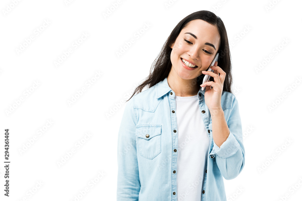 attractive and smiling asian woman in denim shirt talking on smartphone isolated on white attractive and smiling asian woman in denim shirt talking on smartphone isolated on white