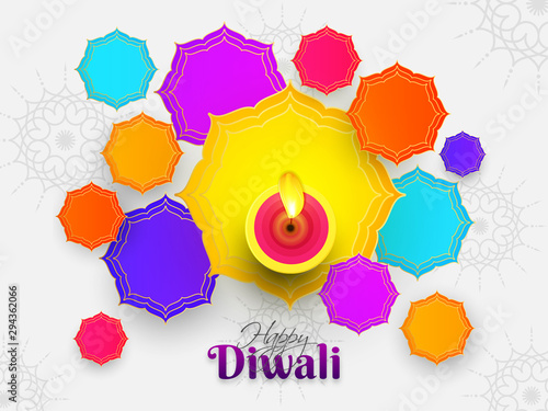 Top view of illuminated oil lamp with colorful abstract design on white background for Indian Festival Diwali celebration. Can be used as greeting card design.