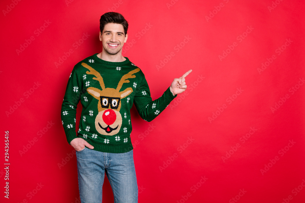 Portrait of content cheerful funny man in deer reindeer point index finger  at copy space recommend shopping christmas ads wear denim jeans isolated  over red color background Stock Photo | Adobe Stock