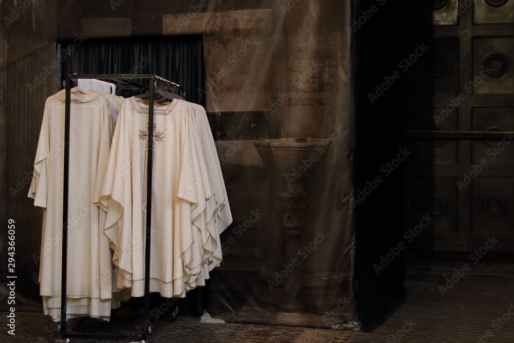 White priests robes hang on a hanger in a temple