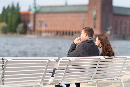 Young couple sitting on a waterfront bench