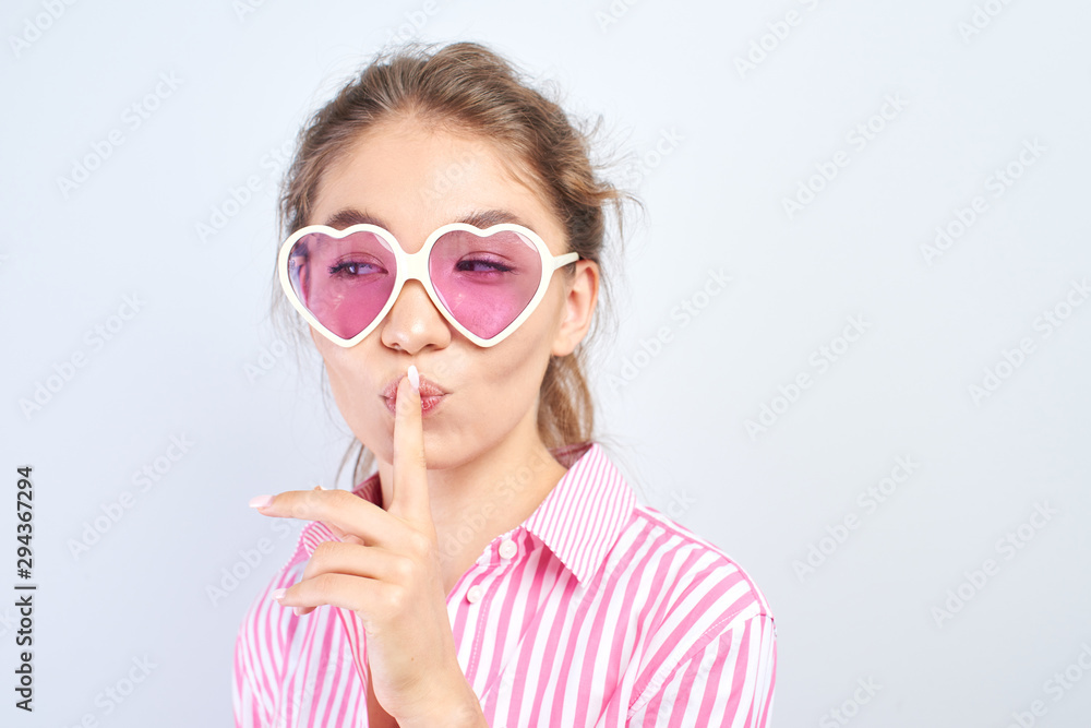 Asian Kazakh girl put her index finger to lips, shh. Concept keep quiet, secret, silence