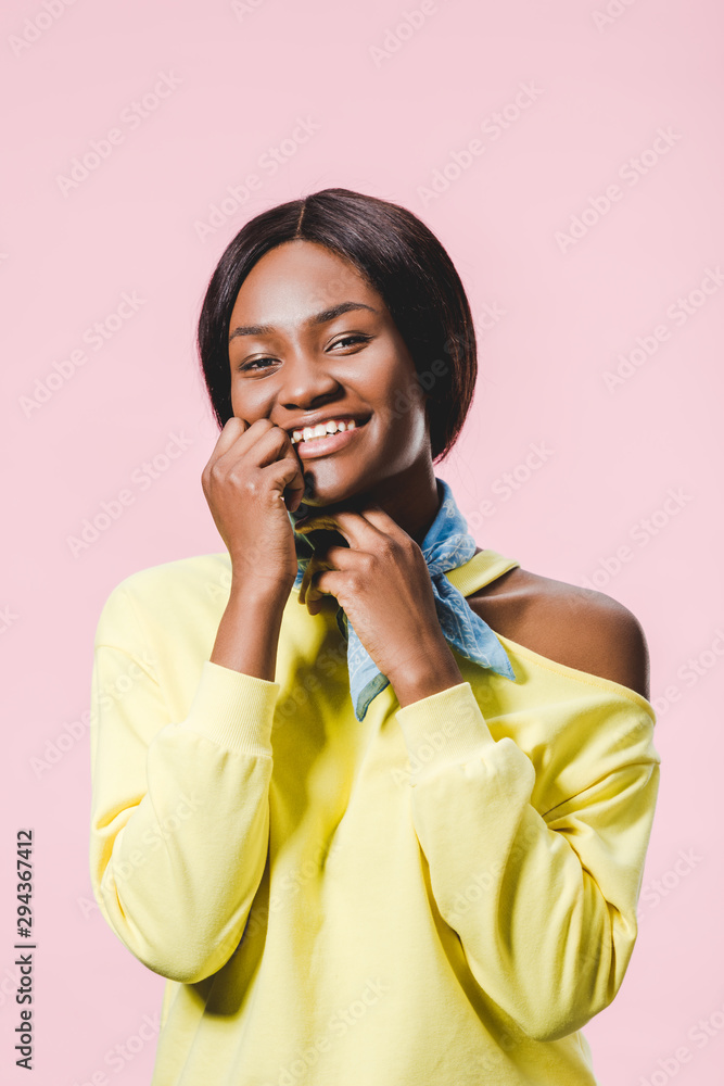 smiling african american woman in yellow pullover and scarf looking at camera isolated on pink smiling african american woman in yellow pullover and scarf looking at camera isolated on pink