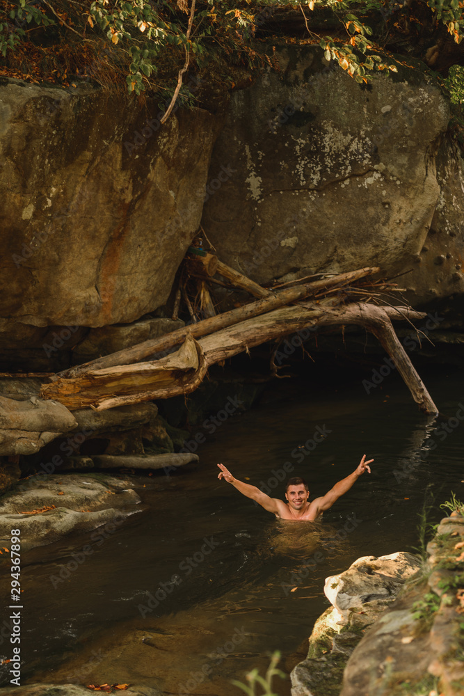 Fototapeta premium A young father and his sons bathe in a mountain river.