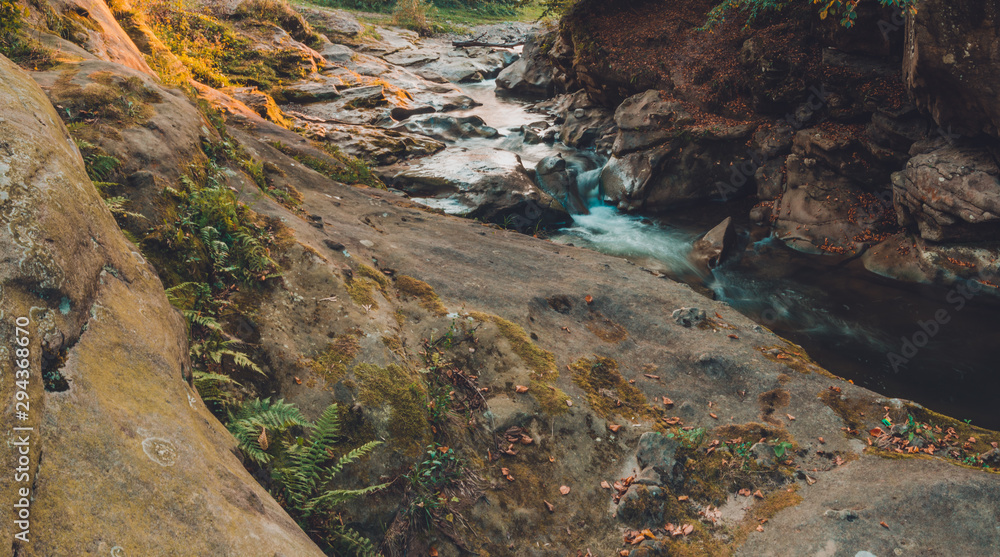 Strong water stream in the high mountain area surrounded by stones with small moss islands in the water body. Strong water stream in the high mountain area surrounded by stones with small moss islands in the water body.