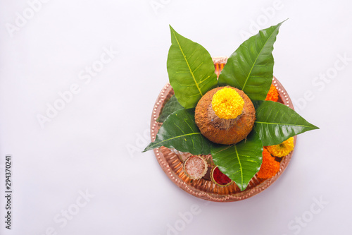 Copper Kalash with coconut ,  Red accounting note book, leaf and floral decoration on a white background. essential in hindu puja. photo