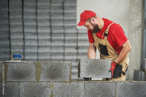 bricklayer working with ceramsite concrete blocks. Walling photo