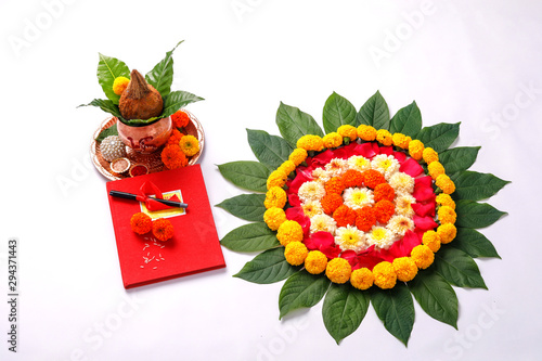  Red accounting note book , diya, and flower rangoli on white background photo