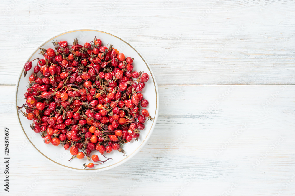 Berries of red rose hips useful for health on a wooden surface Berries of red rose hips useful for health on a wooden surface