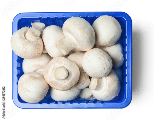 Fresh champignons in plastic packaging isolated on white background. Top view. Clipping path.