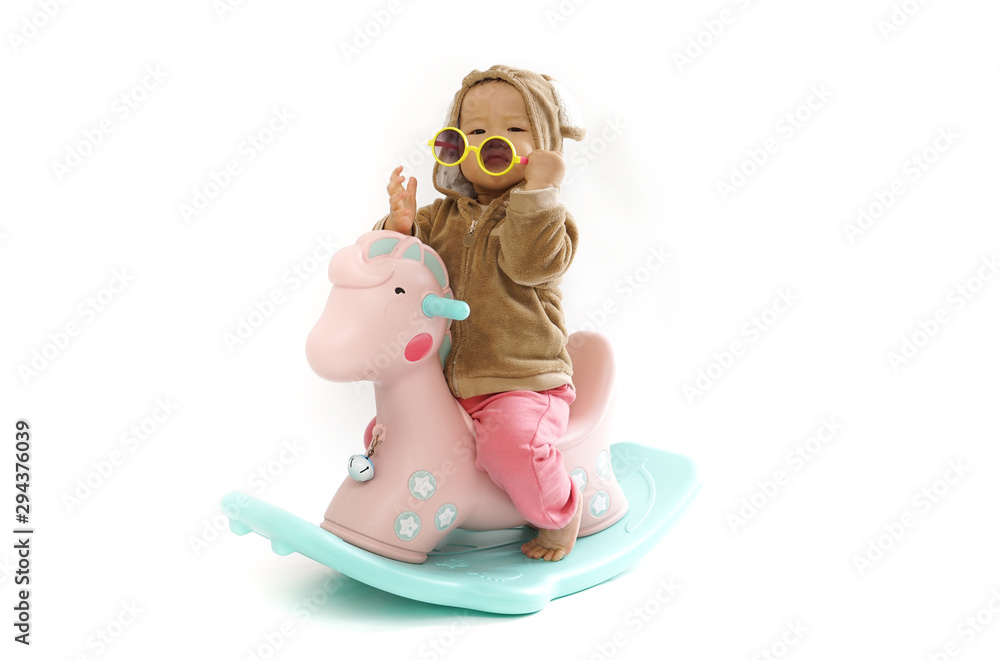 Cute baby riding a wooden horse with a white background Cute baby riding a wooden horse with a white background