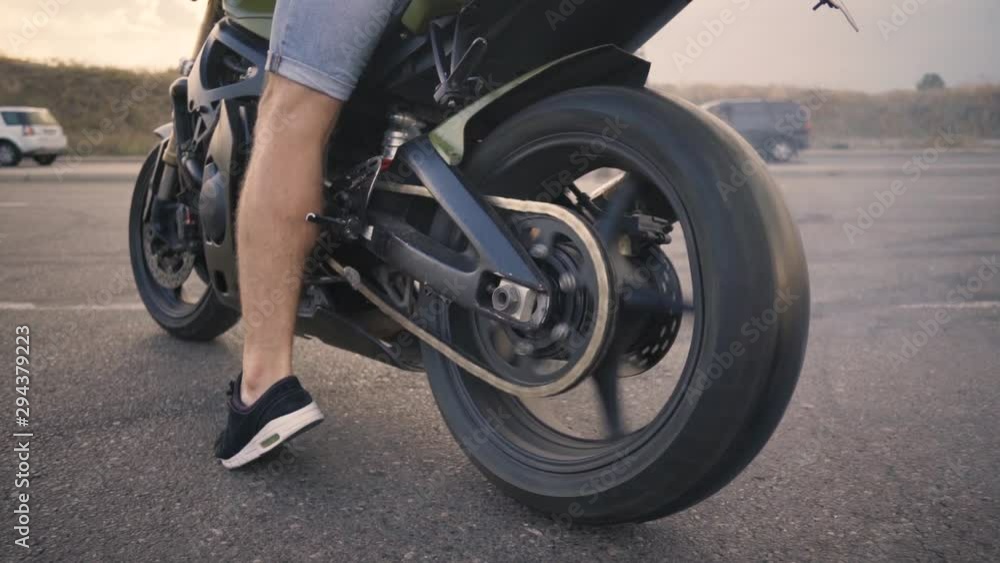 Motorcyclist doing tire burnout on a custom motorcycle, slow motion. Professional motorcyclist drift and turns on a motorcycle on the asphalt, a biker does a trick Motorcyclist doing tire burnout on a custom motorcycle, slow motion. Professional motorcyclist drift and turns on a motorcycle on the asphalt, a biker does a trick