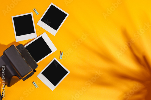 Instant photo frames and camera on a yellow background. Concept of preservation of memories. Flat lay.